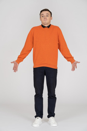 Young man in orange sweatshirt standing