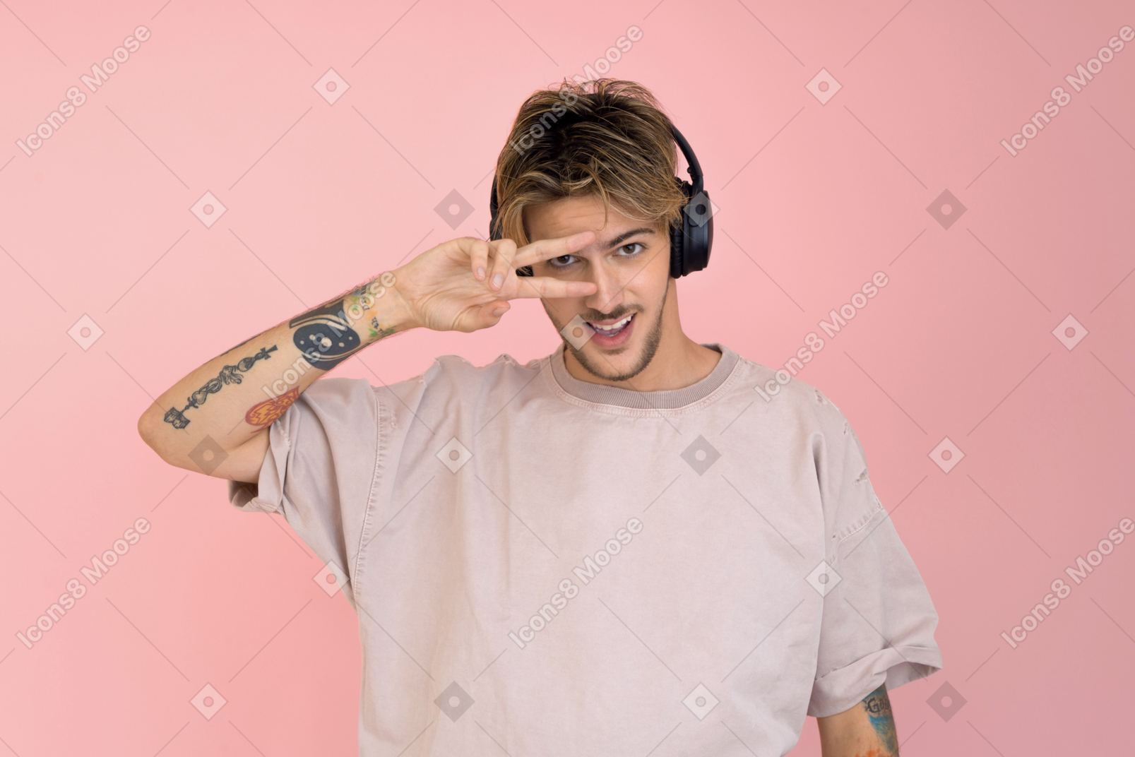 Young man in headphones showing v sign