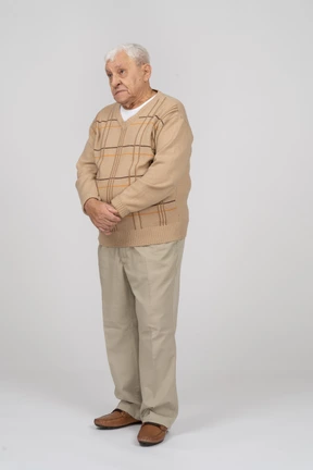 Front view of an old man in casual clothes looking up