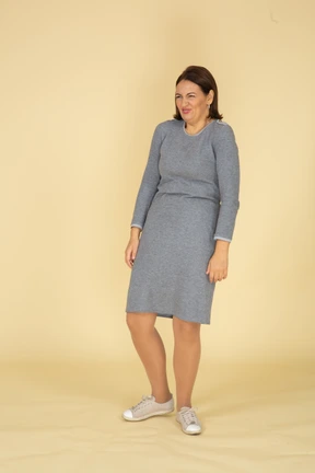 Front view of a woman in grey dress making faces