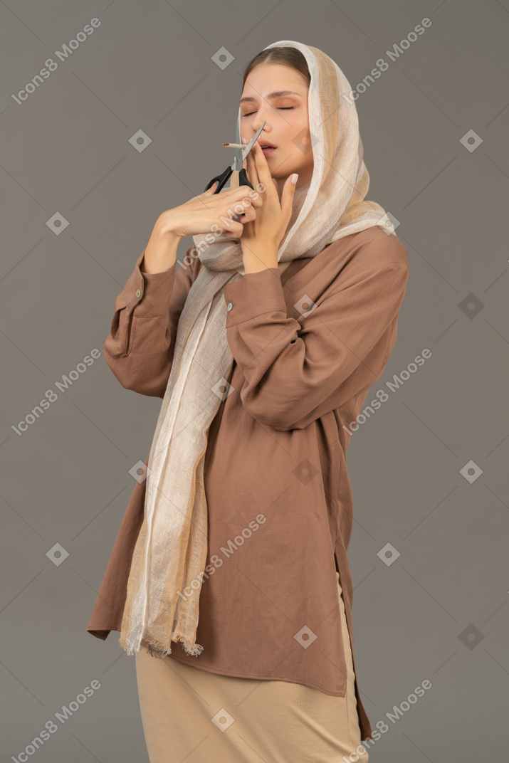 Woman cutting a cigarette with scissors