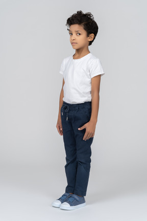 A boy standing with hands alongside body