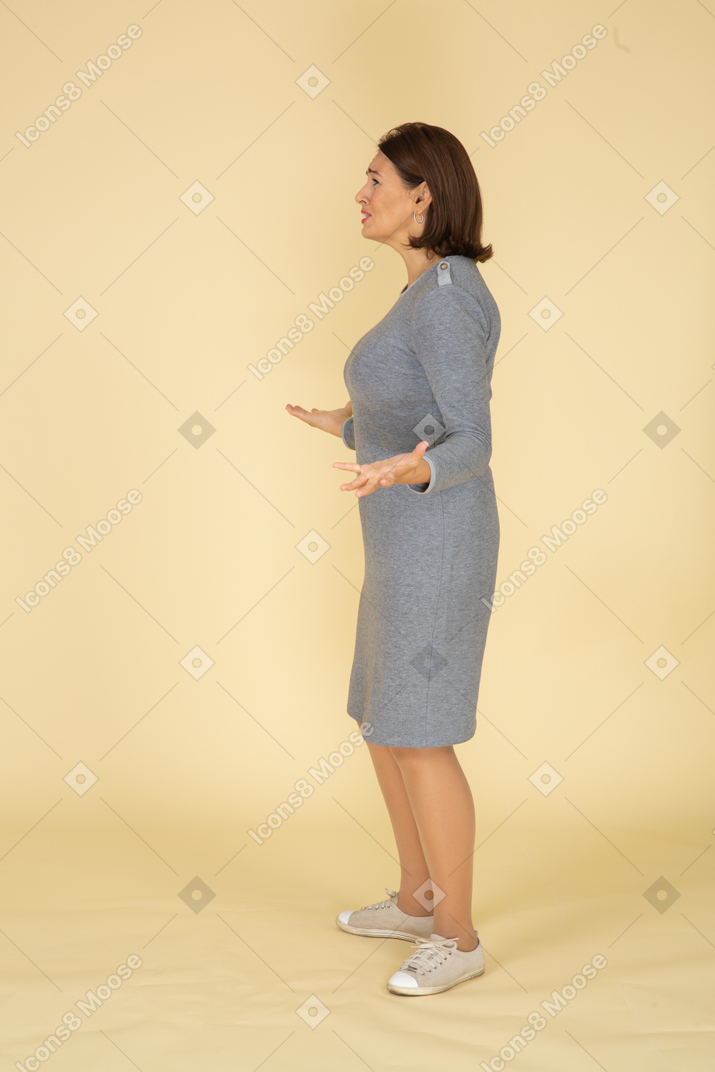 Vista laterale di una donna in abito grigio