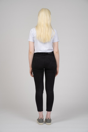 Vista posteriore di una ragazza dai capelli lunghi con le braccia ai lati
