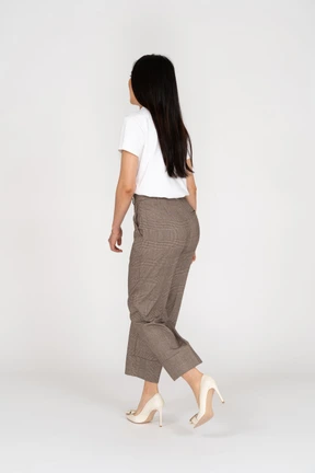 Vista posterior de tres cuartos de una señorita corriendo en calzones y camiseta