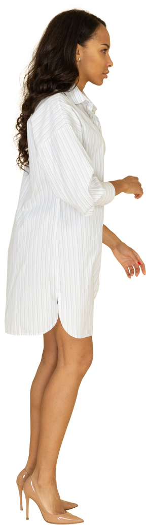 Vista laterale di una giovane donna dalla carnagione scura in abito bianco