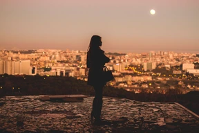 Mujer disfruta de la vista de la ciudad de noche