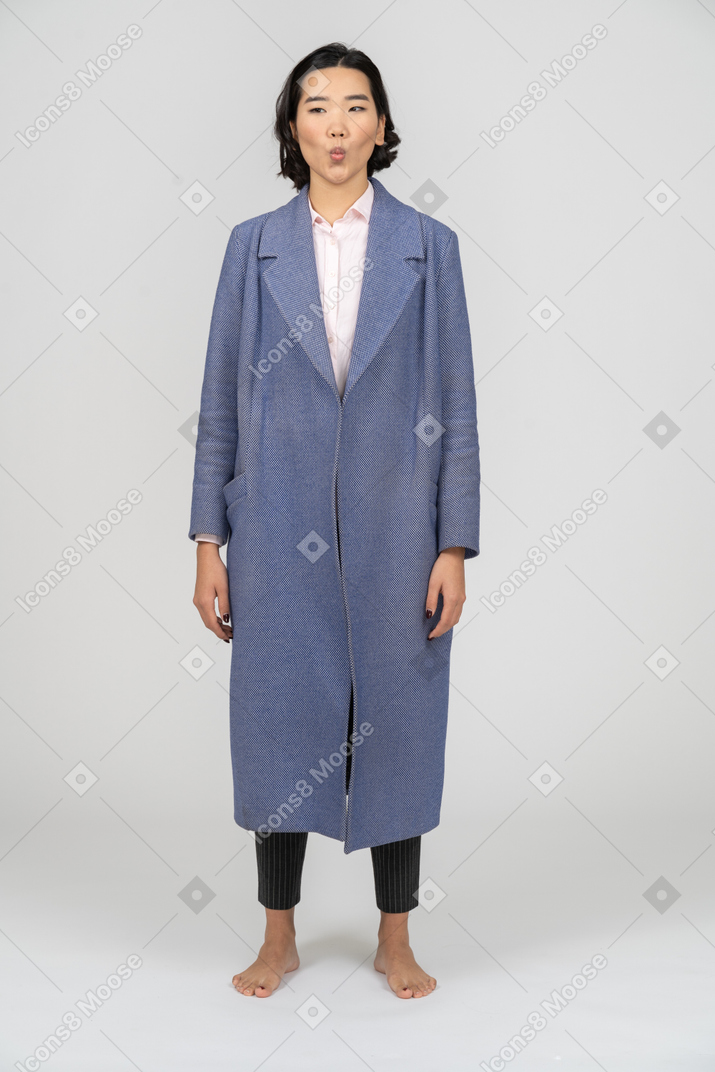 Woman in blue coat sucking in her cheeks