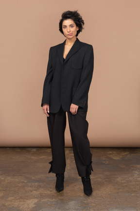 Front view of a grimacing businesswoman in a black suit looking at camera