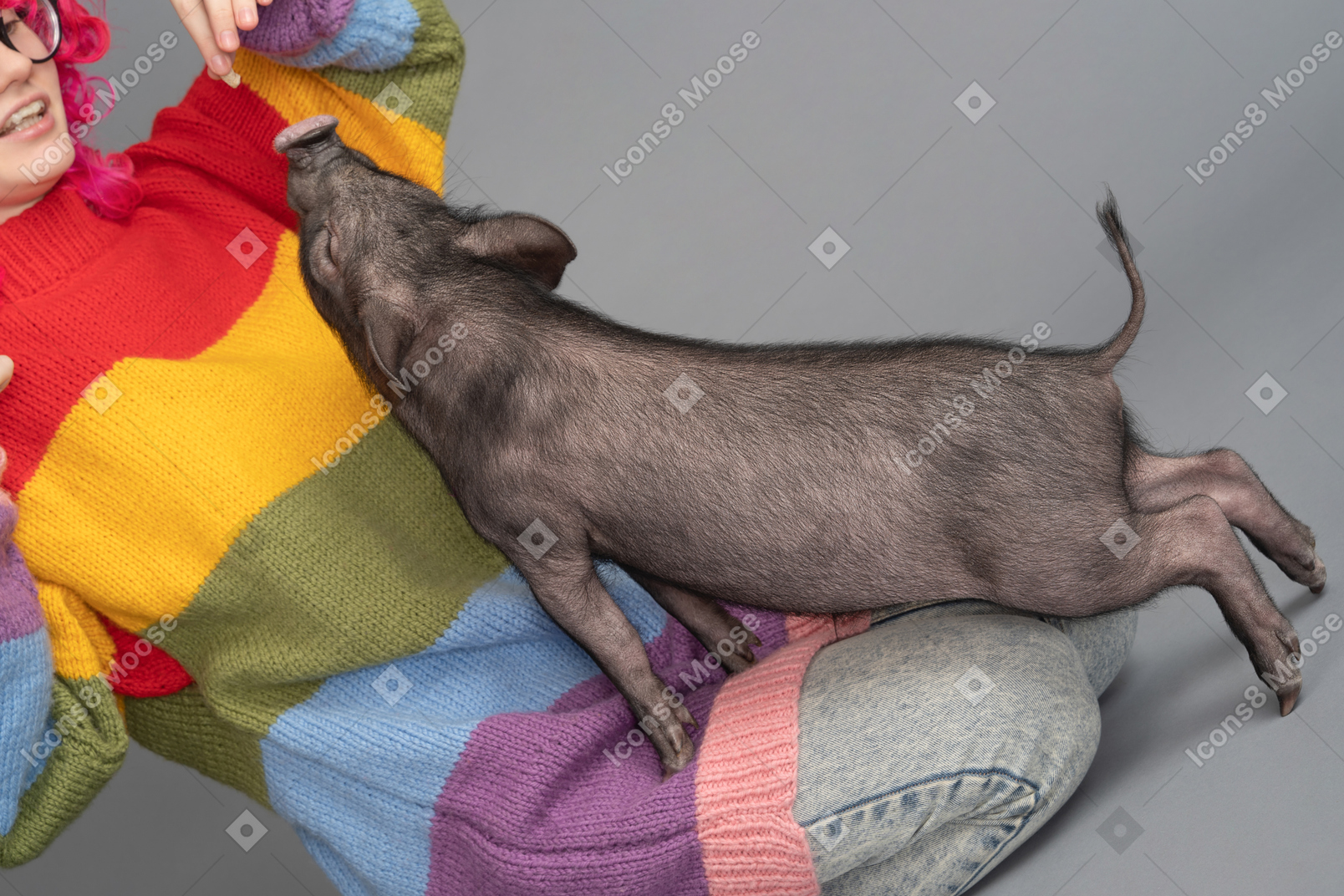A young female playing wit a tiny pet pig