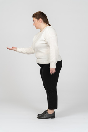 Plump woman in casual clothes making welcoming gesture