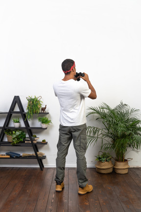 Good looking young man holding binoculars