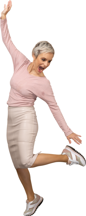 Front view of a happy woman in casual clothes jumping