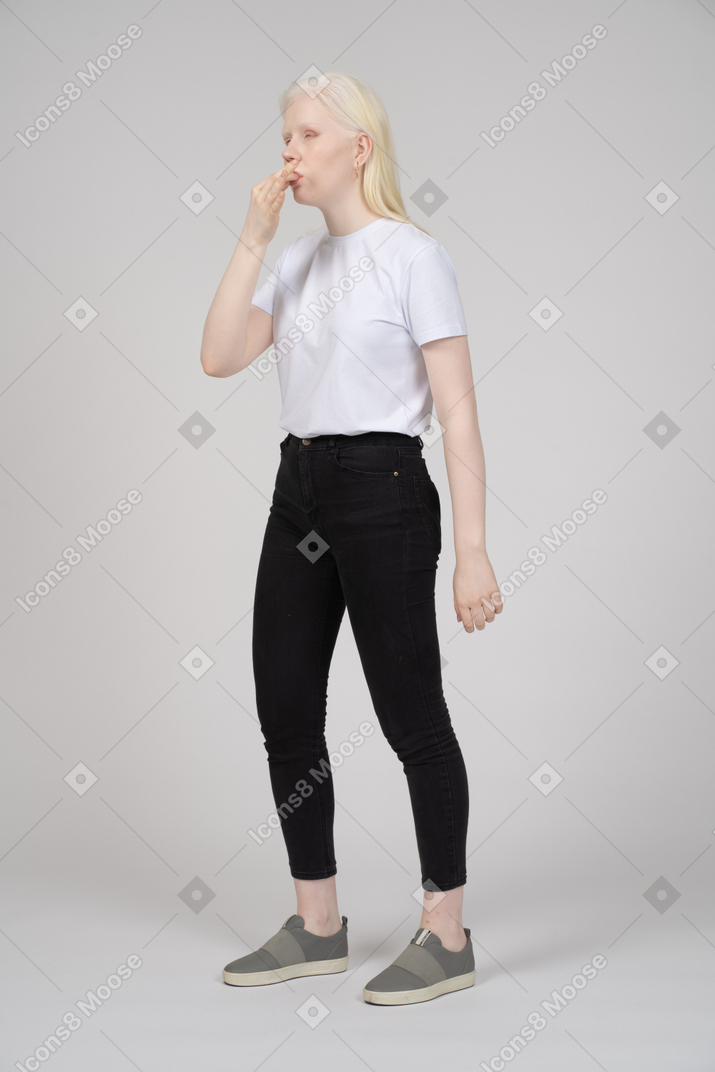 Young woman in casual clothes whistling