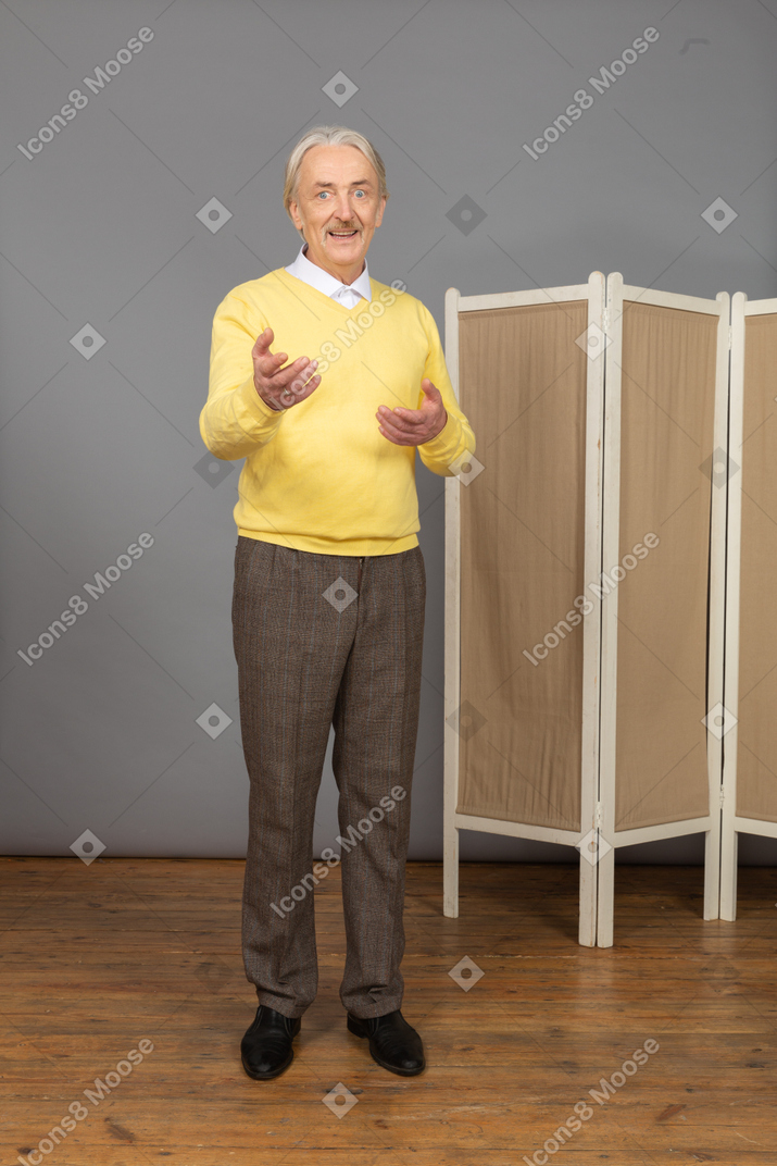 Front view of an old man explaining something while gesticulating