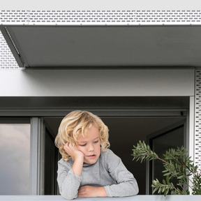 A young boy sitting at a window sill looking out