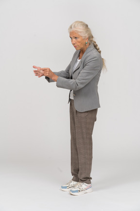 Side view of a serious old lady in suit explaining something