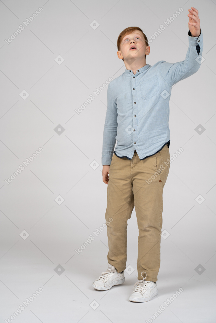 Front view of a boy pointing up with hand