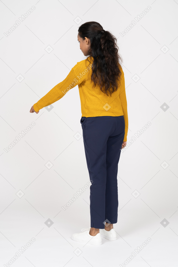 Back view of a girl in casual clothes pointing at something