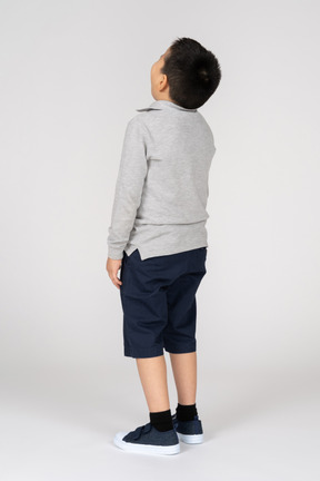 Boy standing and looking up