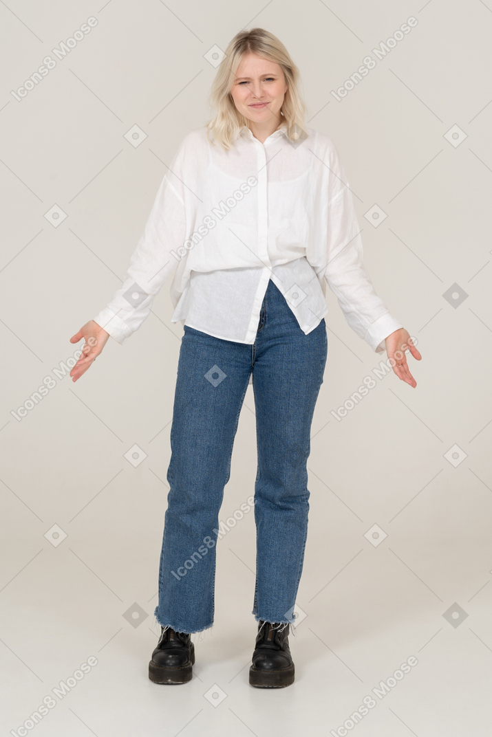 Front view of a blonde female in casual clothes grimacing and outspreading arms