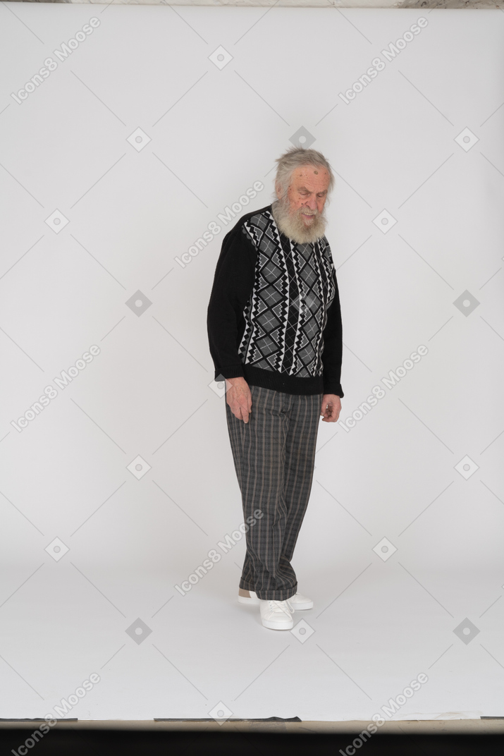 Vista frontale di un uomo anziano che cammina e guarda in basso