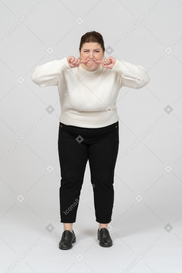 Plump woman in white sweater making faces