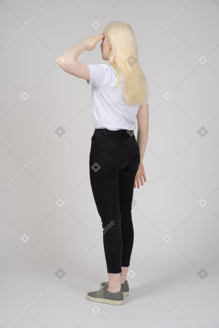 Back view of a blonde woman giving a salute
