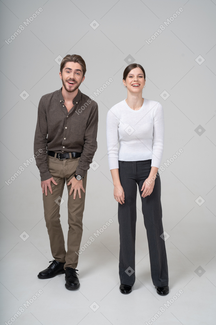 オフィス服で笑っている若いカップルの正面図