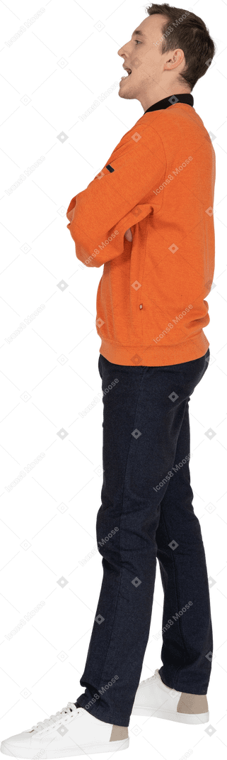 Junger mann im orangefarbenen sweatshirt stehend