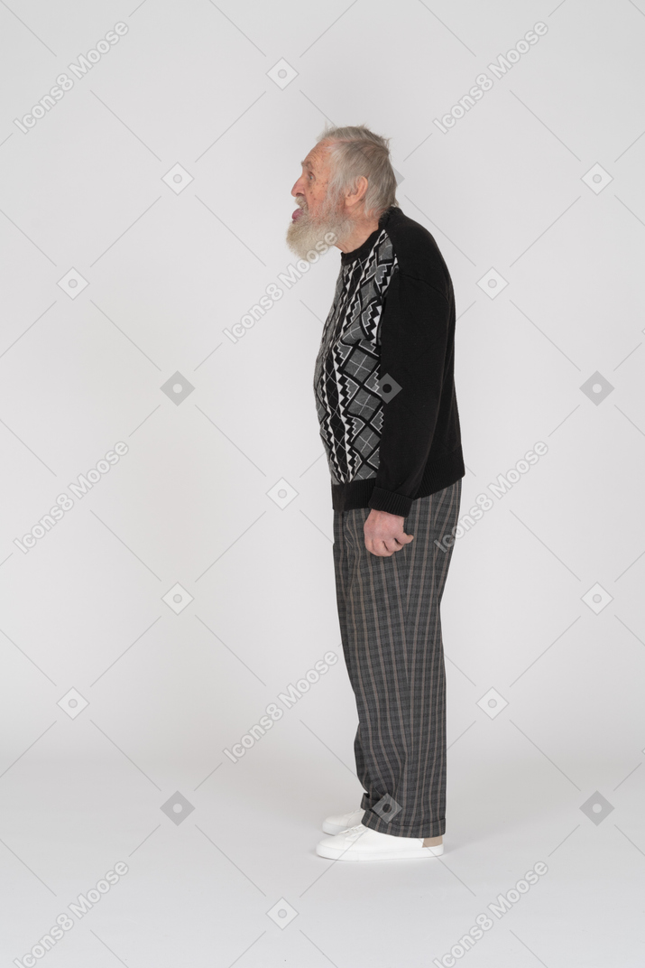 Side view of an old man sticking his tongue out