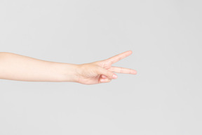 Weibliche hand zeigt v-zeichen horizontal