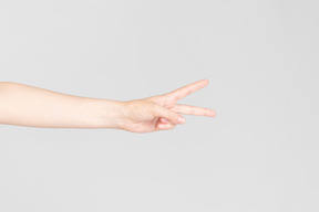 Female hand showing v sign horizontally