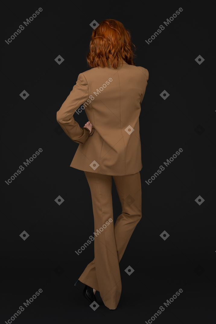 A woman in a tan suit and black shoes