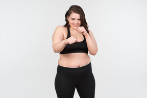 Sorrindo, jovem, plus-size, mulher, ficar, em, lutando, posição