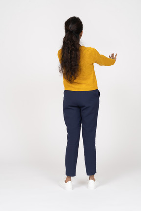 Вид сзади девушки в повседневной одежде, показывающей жест стоп