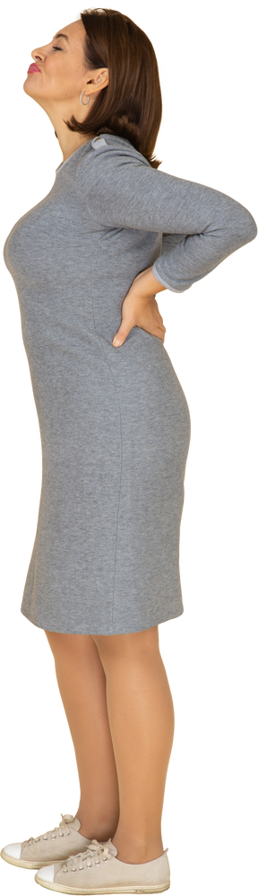 Vue latérale d'une femme en robe grise faisant des grimaces