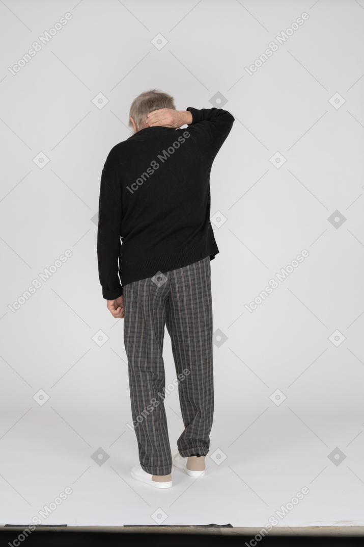 Rear view of old man holding neck