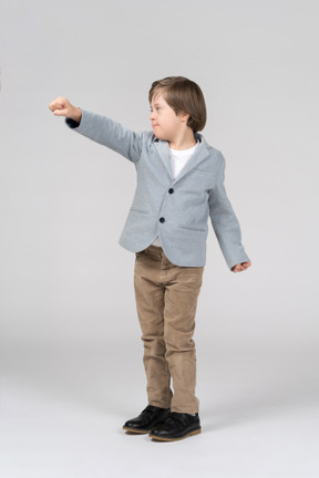 Little boy in suit reaching his fist forward
