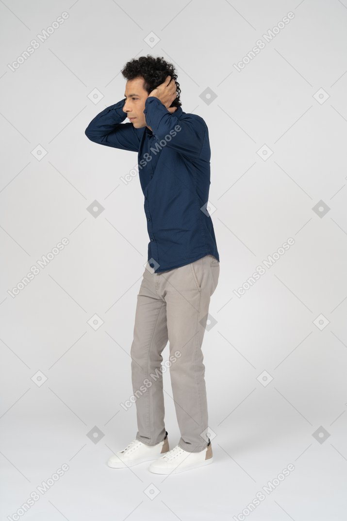 Seitenansicht eines mannes in freizeitkleidung, der die ohren mit den händen bedeckt