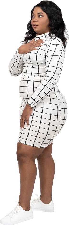 Side view of a beautiful young lady standing with hand on chest