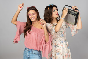 Young girls enjoying music from the stereo