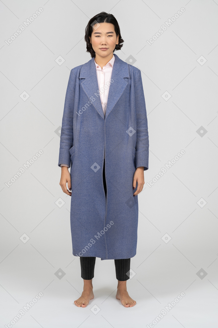 Young asian woman in long blue coat facing the camera