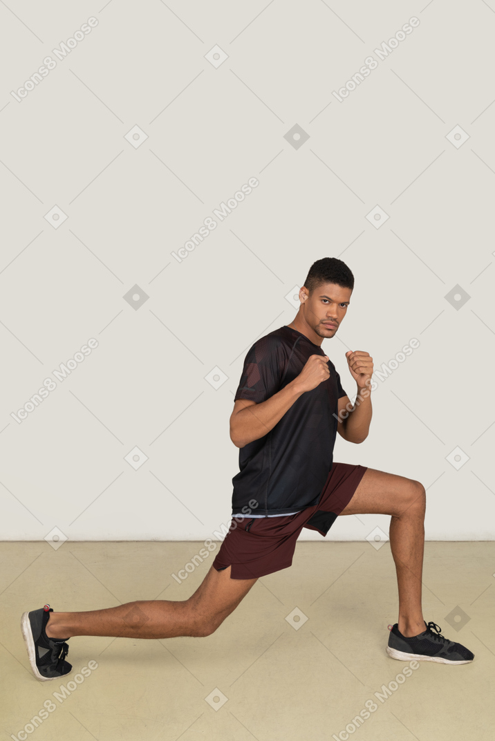 Молодой человек в спортивной одежде делает упражнения