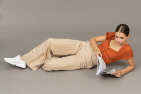 Jovem mulher deitada com um livro