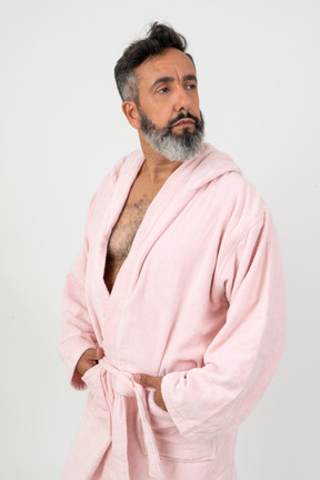 Man in pink robe looking aside