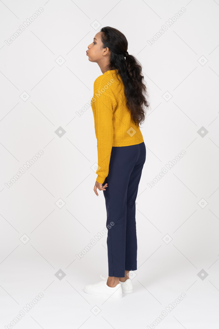 Side view of a girl in casual clothes inflating cheeks