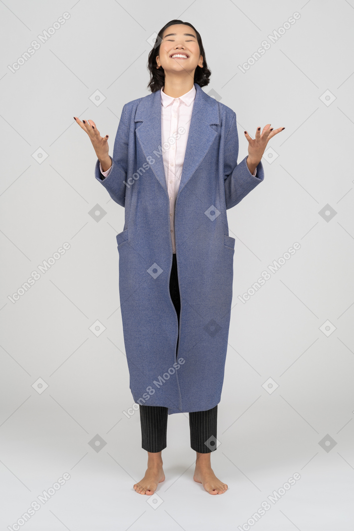 ジェスチャーをする青いコートを着た笑顔の女性