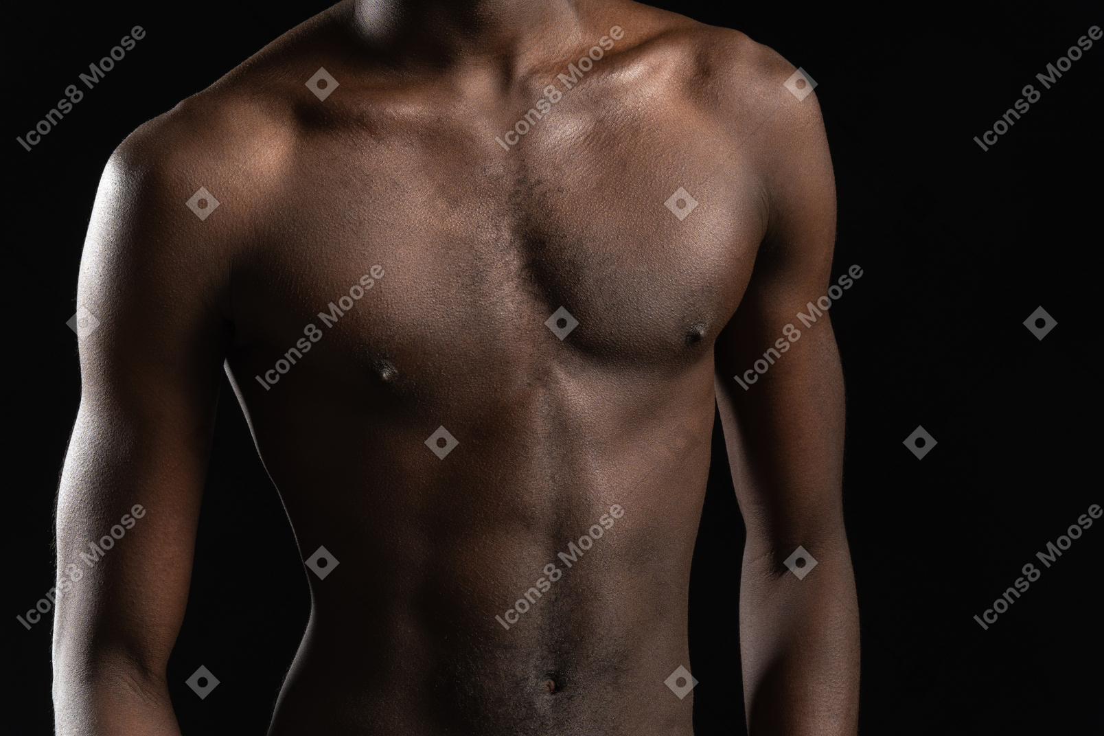 Primer plano de un torso masculino en la oscuridad