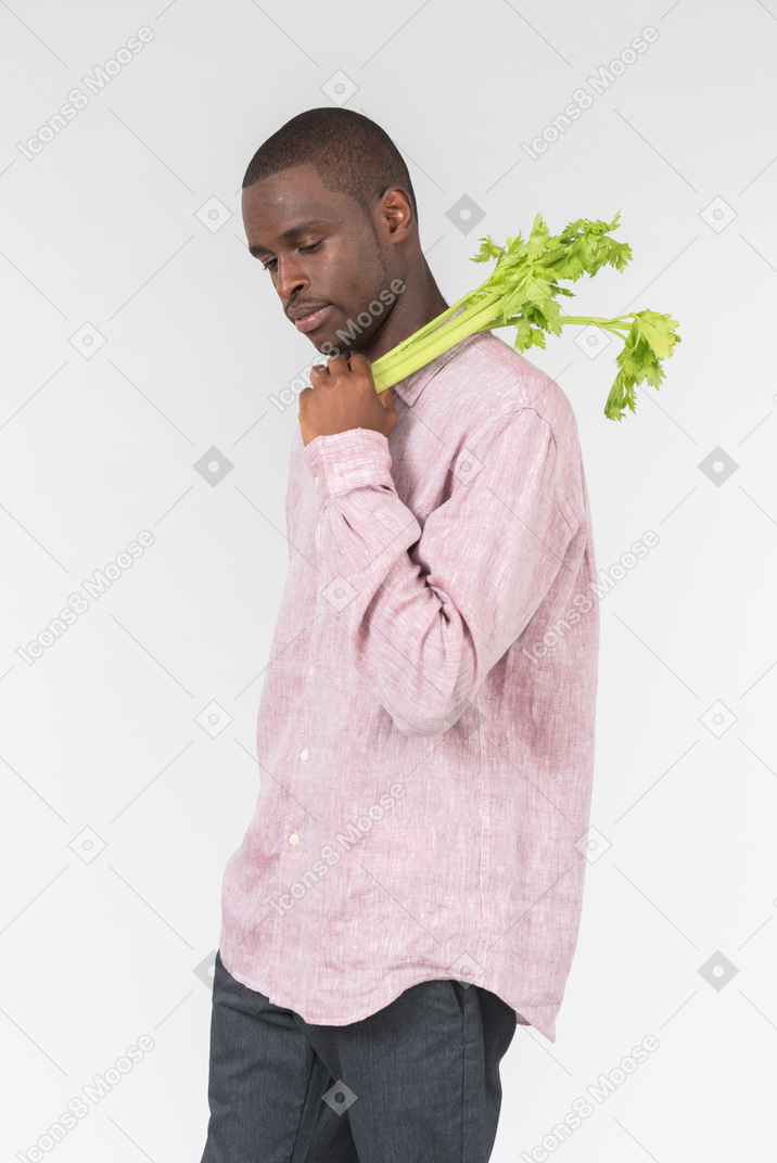 Good looking young man holding a green branch